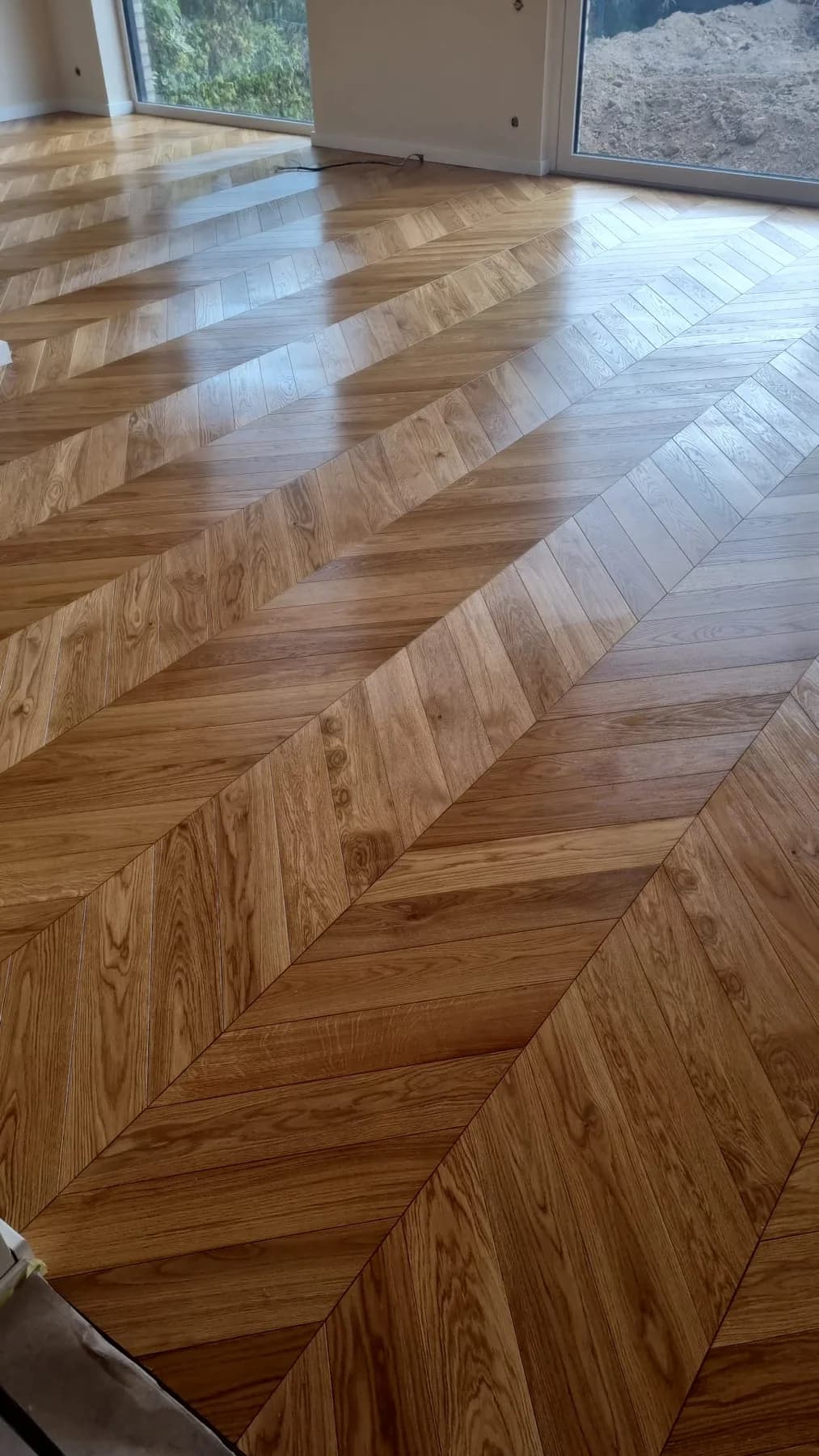 Chevron-Parkett in 45 Grad, frisch verlegt, Blick über die durchlaufenden Spitzen