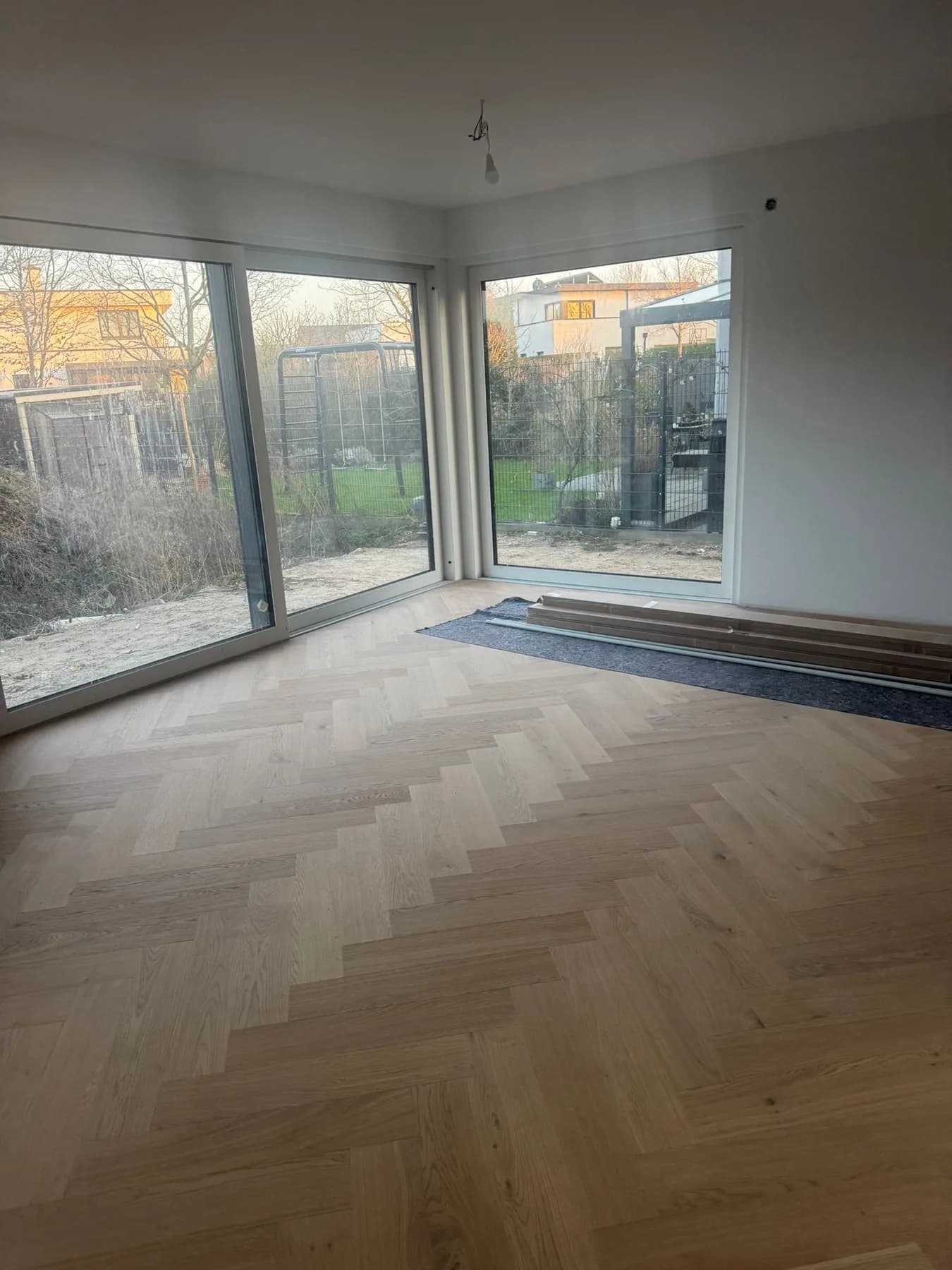 Wohnraum mit bodentiefen Fenstern, Fischgrätparkett bis an die Fensterfront