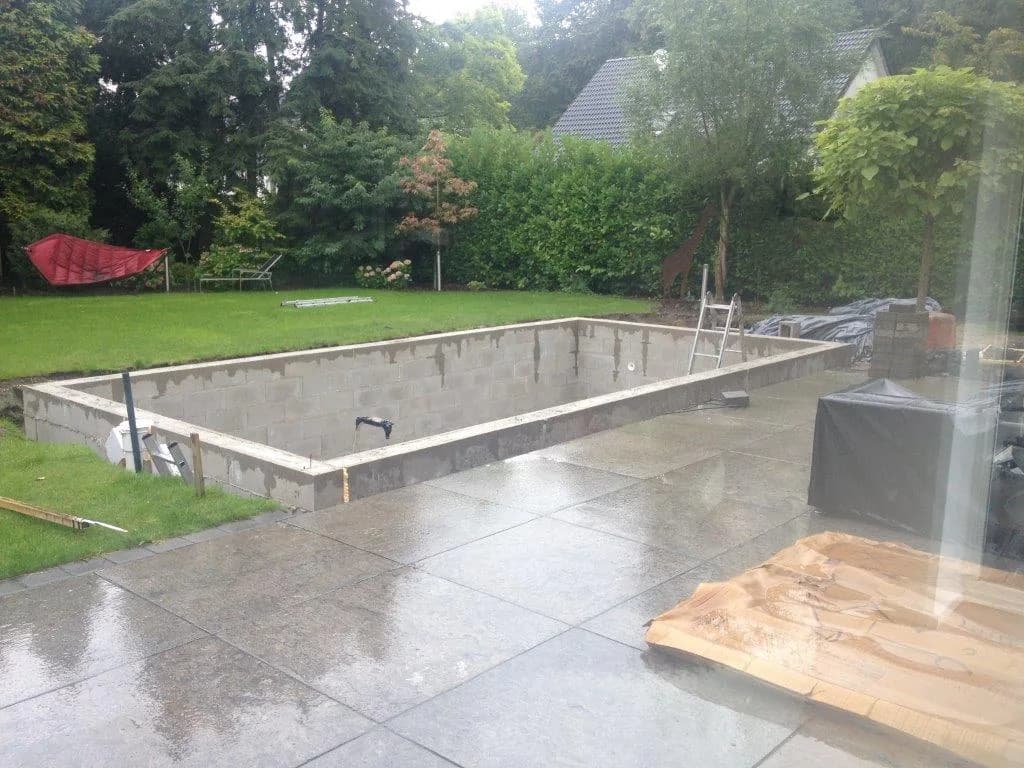Beckenrohbau aus Betonschalungssteinen mit bereits verlegter Blausteinterrasse
