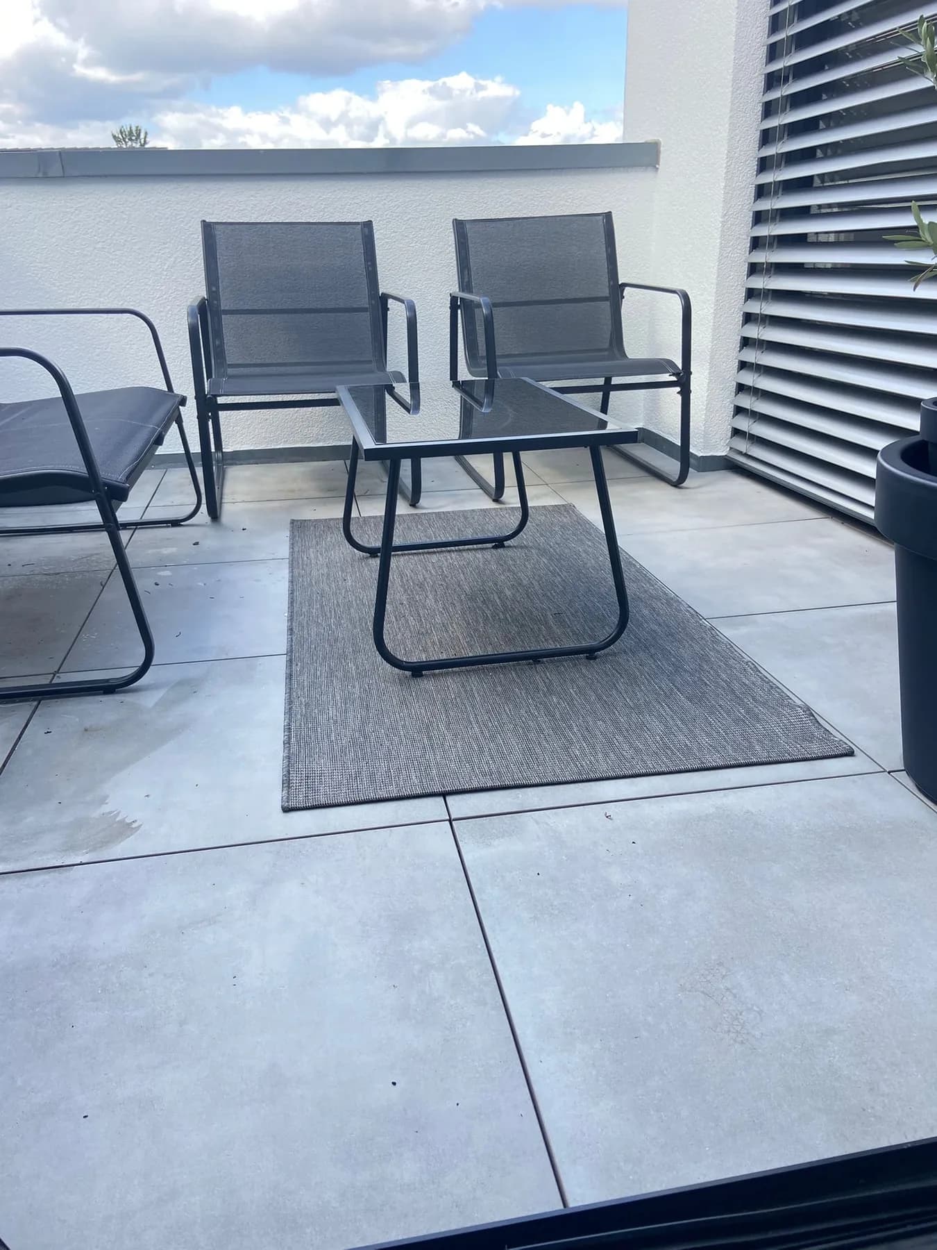 Sitzgruppe auf dem Balkon, graue Keramikplatten, Outdoor-Teppich, Lamellenwand