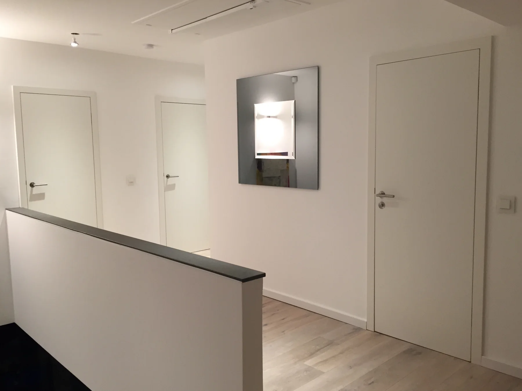 Galerie im Obergeschoss mit weißen Innentüren und umlaufender Brüstung